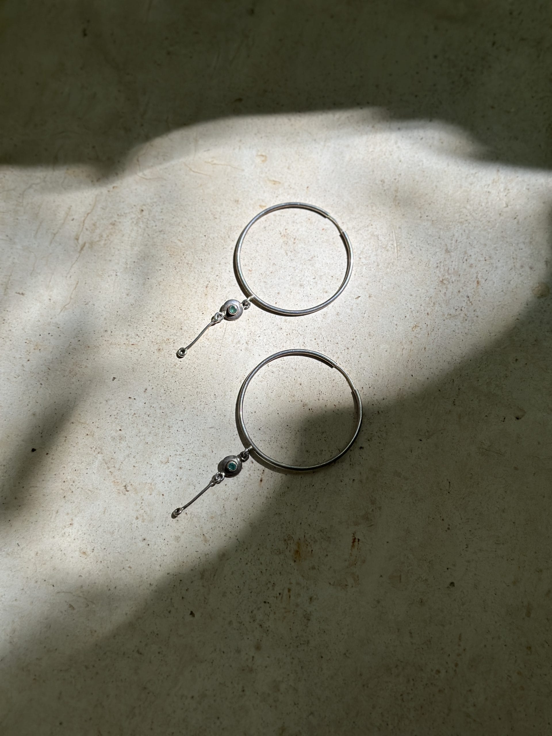 Aretes de aro Mukani sobre piel y luz natural