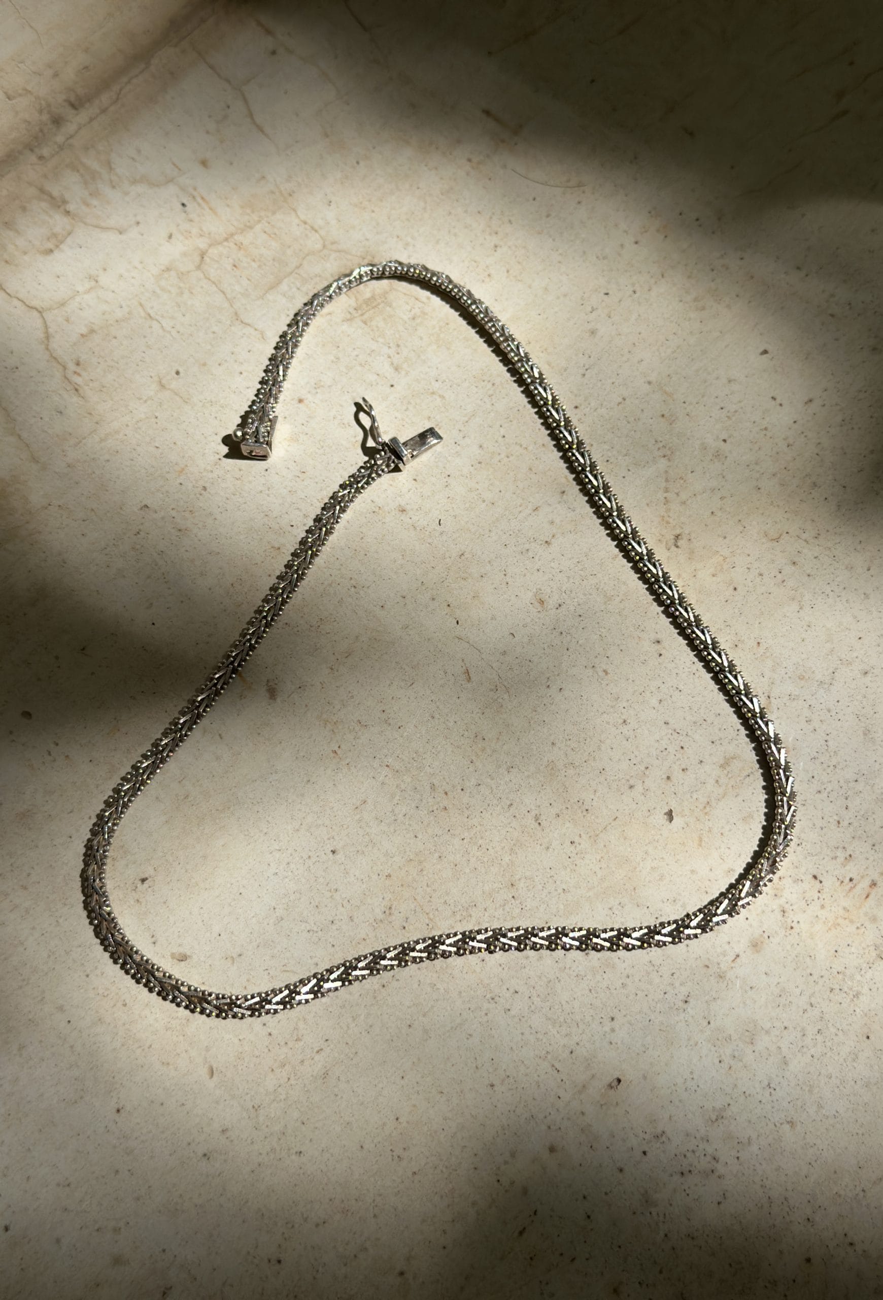 Collar Mukani entre sombras de hojas