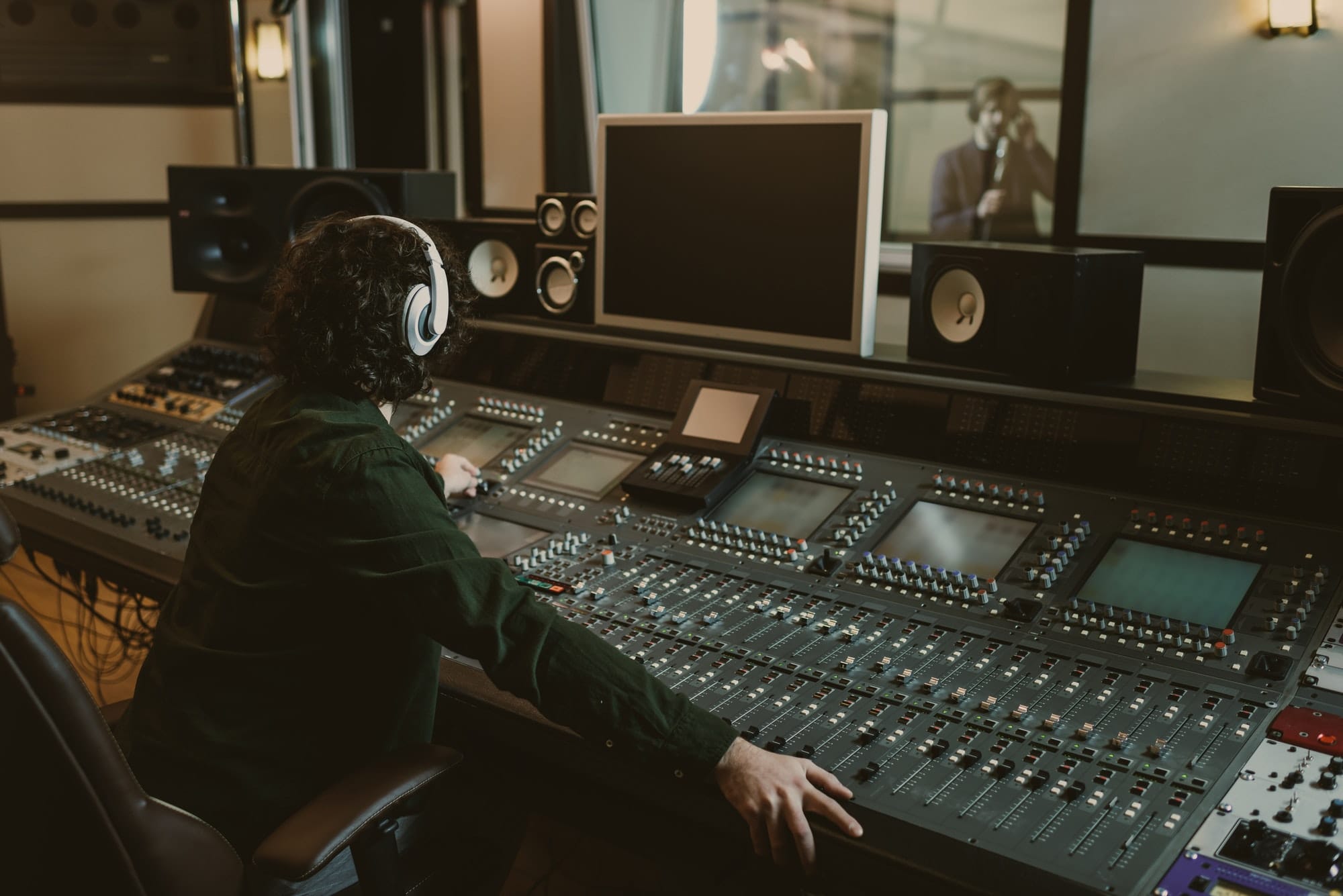 Productor trabajando de espaldas en un estudio de grabación.